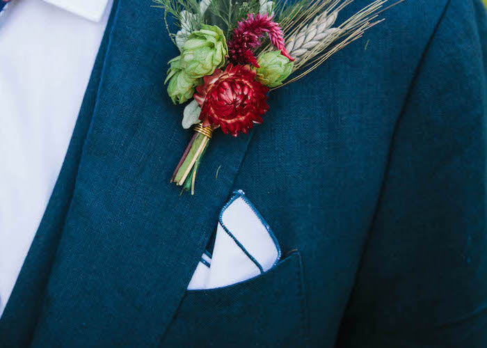 Custom white solid color pocket square in suit pocket with blue accent thread